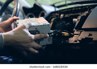 Auto Technician Is Installing A New Car Radio Player Close Up.