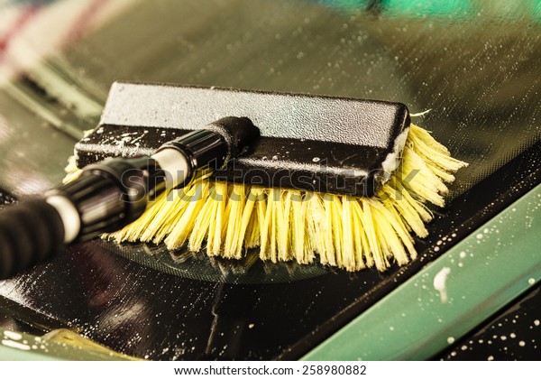 Auto wash closeup. dirty car during washing process\
on open air