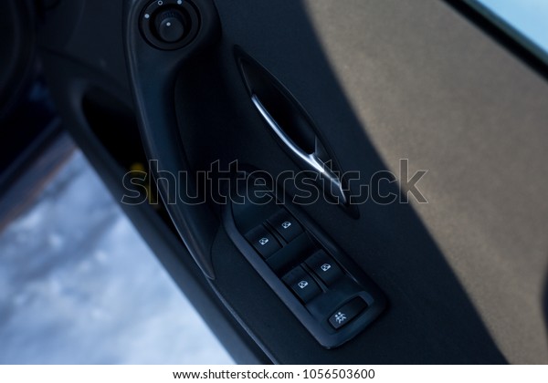 auto window lift buttons. the door in the car.\
buttons on the car door\
handle