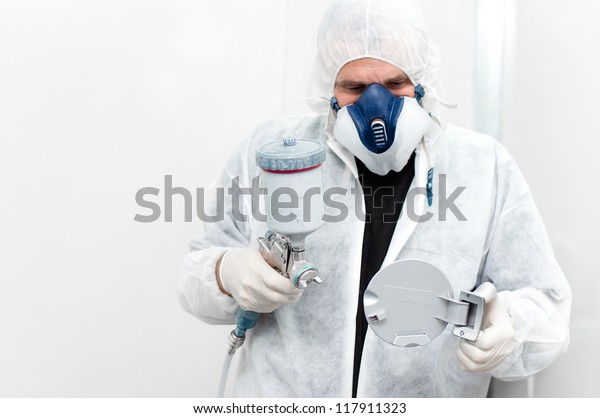 auto
worker painting a car body component with spray
gun