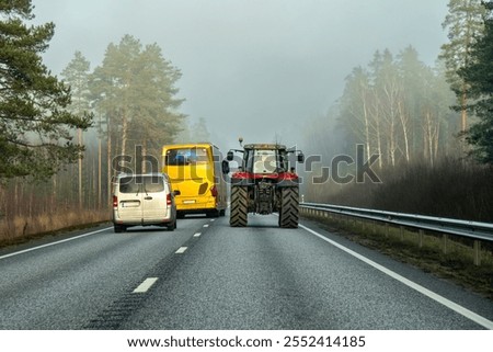Autobus performs dangerous overtaking of the tractor by car and in highway fog.