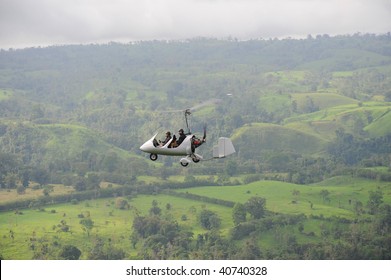 Autogyro flying above the tropical landscape