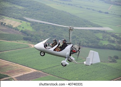Autogyro flying over the tropical landscape