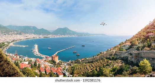 Autogyro with two tourists flies over the beach of Alanya, panoramic view