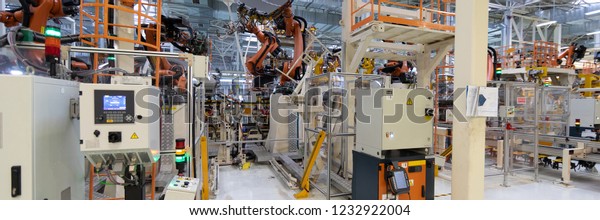 Automated Assembly process of\
cars by robots. Automotive production line. long format. Wide\
frame