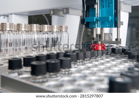 Automated autosampler needle injecting sample into vials on a chromatography laboratory machine