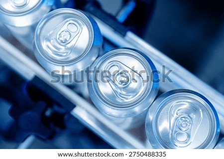 Automated beer canning process in modern brewery, blue neon light top view.