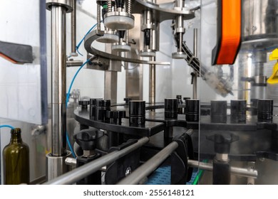 Automated bottling line for extra virgin olive oil production with quality control system and precision machinery. Close-up view of industrial filling equipment. - Powered by Shutterstock