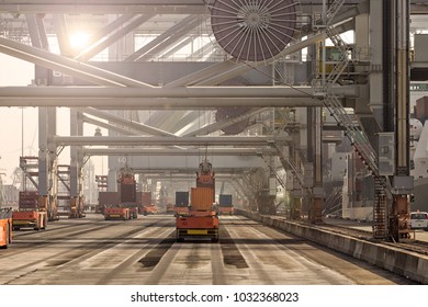 Automated Guided Vehicles Moving Shipping Containers To And From Gantry Cranes In A Port Container Terminal.