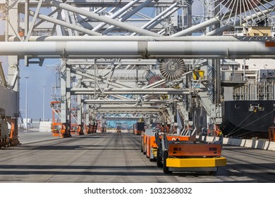 Automated Guided Vehicles Moving Shipping Containers To And From Gantry Cranes In A Port Container Terminal.