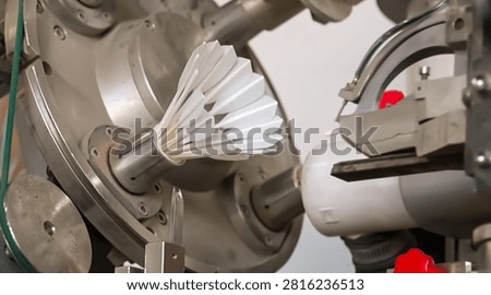 Automated machine binding thread around badminton shuttlecock feathers in factory