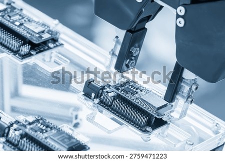 The automated material handling process using an industrial robotic arm to move assembled PCBs onto a production line. This process demonstrates the high-precision, high-speed pick-and-place technology that is key to modern electronics manufacturing.