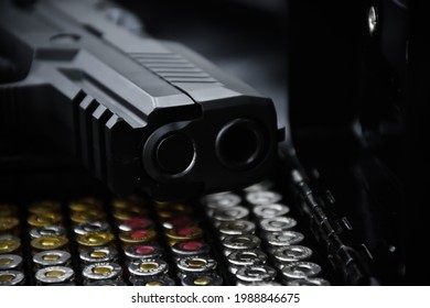 Automatic 9mm black pistol and bullet on black background. Soft and selective focus on muzzle of pistol.
