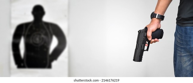 Automatic 9mm Pistol Gun Holding In Right Hand Of Shooter In Front Of Blurred Man-target Shooting Paper, Concept For Training To Shoot Guns For Custody And Crime Prevention