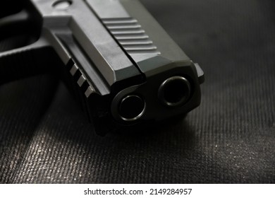 Automatic 9mm pistol gun on black leather background, soft and selective focus.