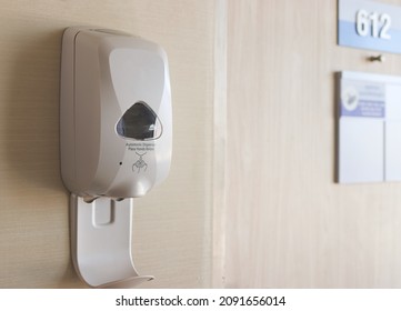 Automatic Alcohol Gel Dispenser  On The Wall At The Entrance Of Hospital Room Number 612. Hand Sanitizer In Hospital.