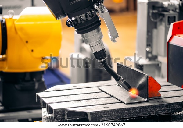 Automatic arm Industrial robot CNC\
welding metal production in factory with sunlight\
spark.