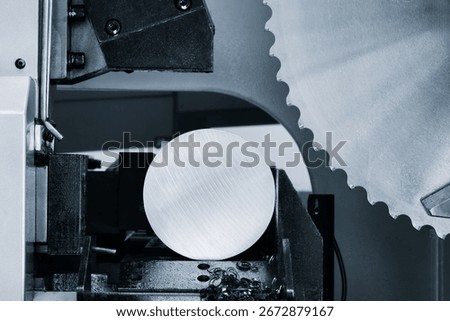 The automatic band saw machine cutting the metal bar with coolant method. The machine tool for industrial purpose.