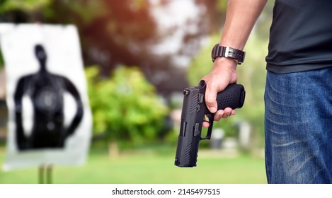 Automatic Black 9mm Pistol Gun Holding In Hand Of Shooter, Ready To Shot The Man-target Shooting Paper Ahead, Concept For Training And Practising Human To Be Body Guard, Vip Protecters And Gangsters.