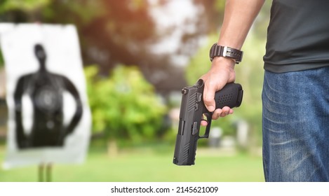 Automatic Black 9mm Pistol Gun Holding In Hands Of Shooter, Ready To Shot The Man-target Shooting Paper Ahead, Concept For Training And Practising Human To Be Body Guard, Vip Protecters And Gangsters.