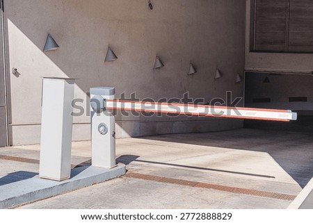 Automatic boom arm barrier blocking vehicle access to a parking garage, ensuring security and controlled entry