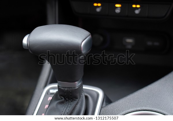 Automatic car gear with leather details and chrome
elements with selective focus and blurred lighting buttons on
background. Car interior with new gear stick. Automobile
transmission gearshift
