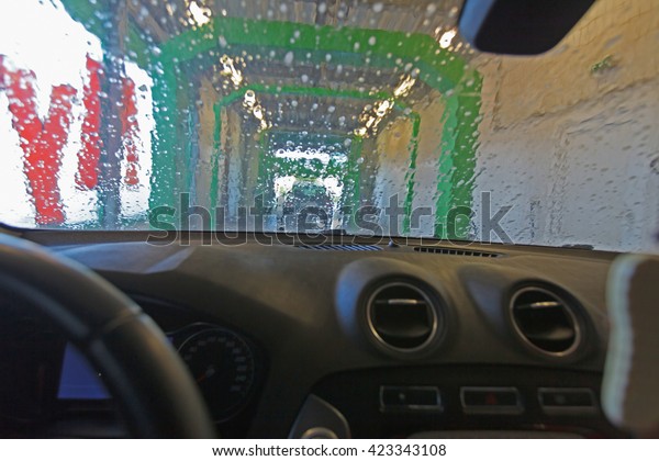 Automatic car wash. View from the car of\
a passing car washer (unfocused, blurry\
effect).