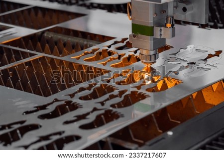 Automatic cnc laser cutting machine working with sheet metal with many sparks at factory, plant. Metalworking, technology, industrial, manufacturing and equipment concept