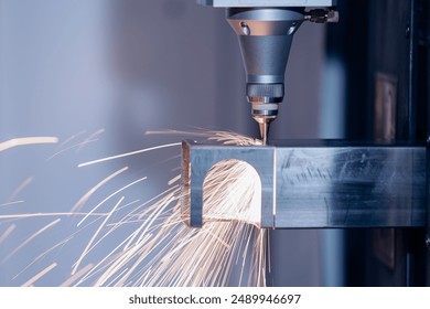 Automatic CNC machine Laser for cut of metal profile of square section with light spark. Concept Modern industrial technology.