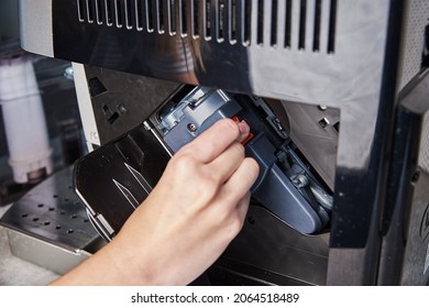 Automatic coffee machine cleaning. Woman inserts mechanism inside coffee machine. Household appliances maintenance