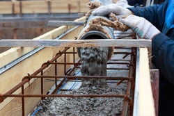 Automatic Concrete Feed Using A Concrete Pump For Filling Reinforced Beams, Close-up With A Blurred Background, Builder Fills With The Concrete Reinforcement Frame, Construction Of A Private House