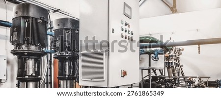 Automatic control systems. Industrial pumps in an engine room. Industry interior of water pump, valves, pressure gauges, motors inside technical room. Urban modern powerful pipelines. Copy text space