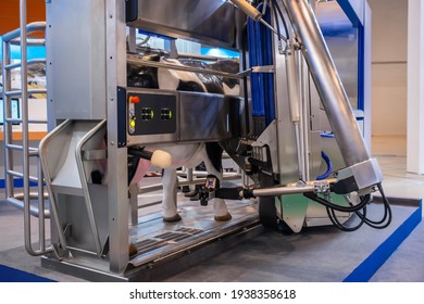 Automatic Cow Milking Robot Arm Machine Demonstrates Functionality At Cattle Dairy Farm, Exhibition, Trade Show. Farming, Automated Technology Equipment, Agriculture Industry, Animal Husbandry Concept