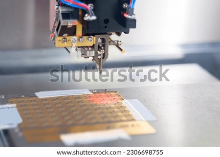 Automatic desktop wire bonder machine during work at exhibition or trade show - close up. Automated technology, industrial, robotic, electronic, production, manufacturing concept