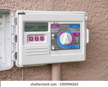 Automatic electric outdoor irrigation timer. Closeup of programmable lawn watering system.