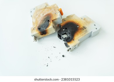 Automatic electrical switch damaged by short circuit, ash on background, isolated on white background. Selective focus, noise. Fire hazard