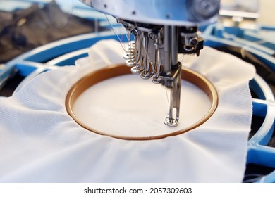 automatic embroidery machine, close up automatic embroidery machine, garment employees operating automatic embroidery machines, suitable for garment, textile.fasion world. sewing. factory. industry.