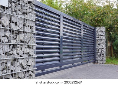 Automatic entrance gate used in combination with a wall made of gabion.