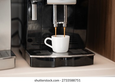 Automatic espresso machine preparing fresh espresso, hot coffee flowing into white ceramic cup. Morning routine for a caffeine dose