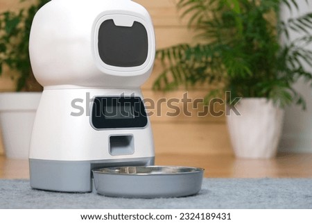 an automatic feeder. Automatic pet food dispenser on the floor of the house. A smart pet feeder.