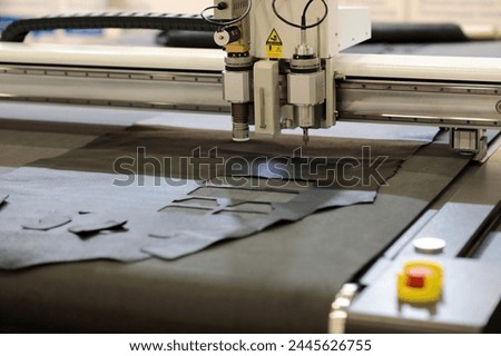 Automatic flatbed digital cutting system close up. CNC leather cutting machine. Selective focus.
