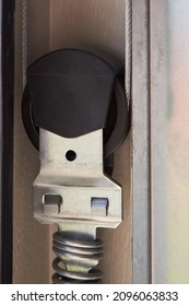 Automatic Garage Door mechanism close up. Lifting gates of the garage. Metal wheel, Springs tensioning, handle, fastening of a garage door. 