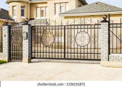 Automatic gate with forged elements of black color in the cottage