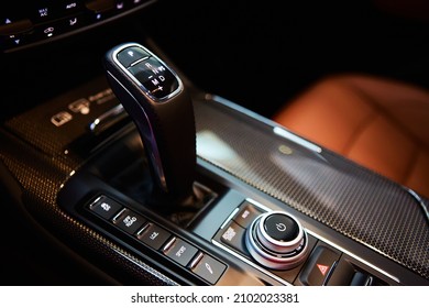 Automatic gear stick of a modern car, multimedia and navigation control buttons. Car interior details. Transmission shift. Shallow dof - Shutterstock ID 2102023381