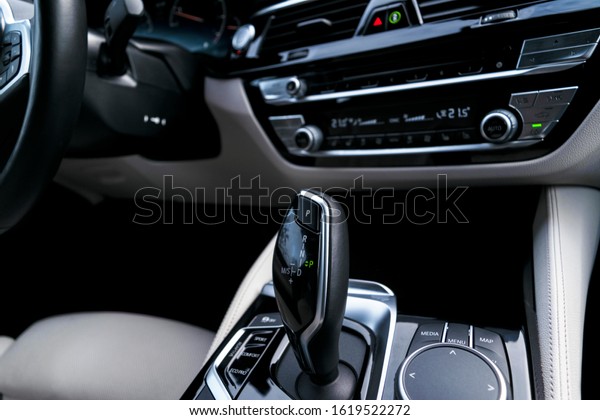 Automatic gear stick of\
a modern car. Modern car interior details. Close up view. Car\
detailing. Automatic transmission lever shift. White leather\
interior with stitching\
