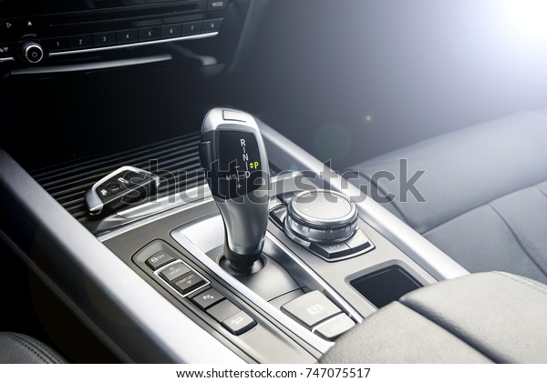 Automatic gear stick of a modern\
car and wireless car key, car interior details. Soft\
lighting