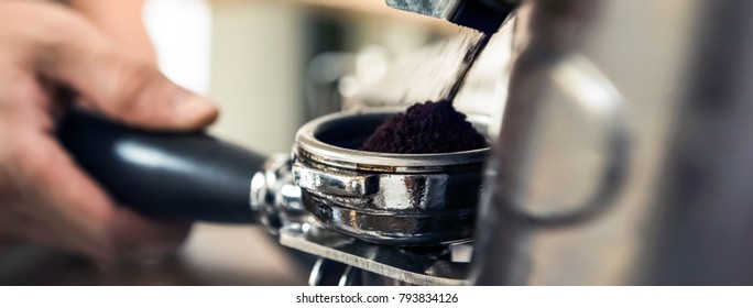 Automatic grinder machine grinding coffee beans into portafilter basket