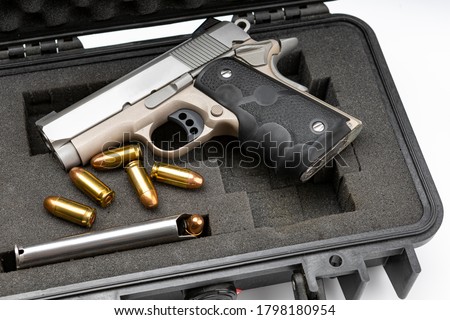 Automatic gun and bullets in a plastic hard case on white background
