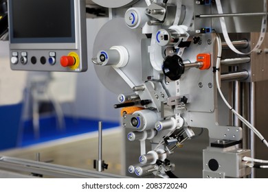 Automatic labeling machine applies stickers with QR code. Selective focus.