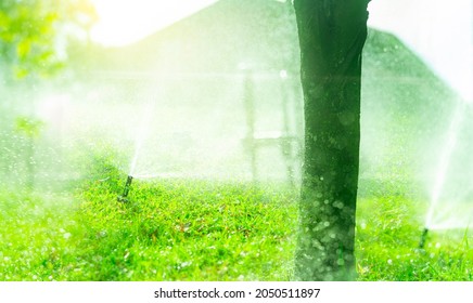 Automatic lawn sprinkler watering green grass. Sprinkler with automatic system. Garden irrigation system watering lawn. Sprinkler maintenance service. Home service irrigation sprinkler. Water splash. - Shutterstock ID 2050511897